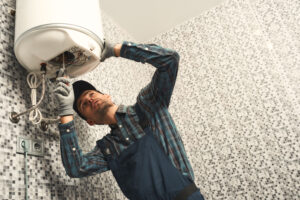 Plumber repairing a water heater in bathroom
