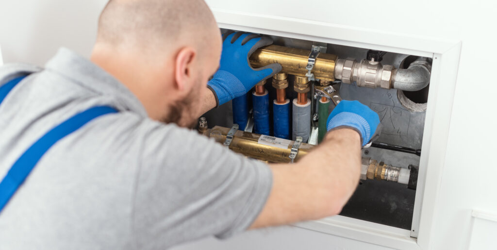 Plumber repairing heating system pipes