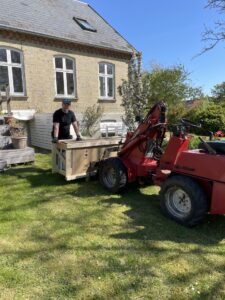 Person unloading wooden crate with red forklift